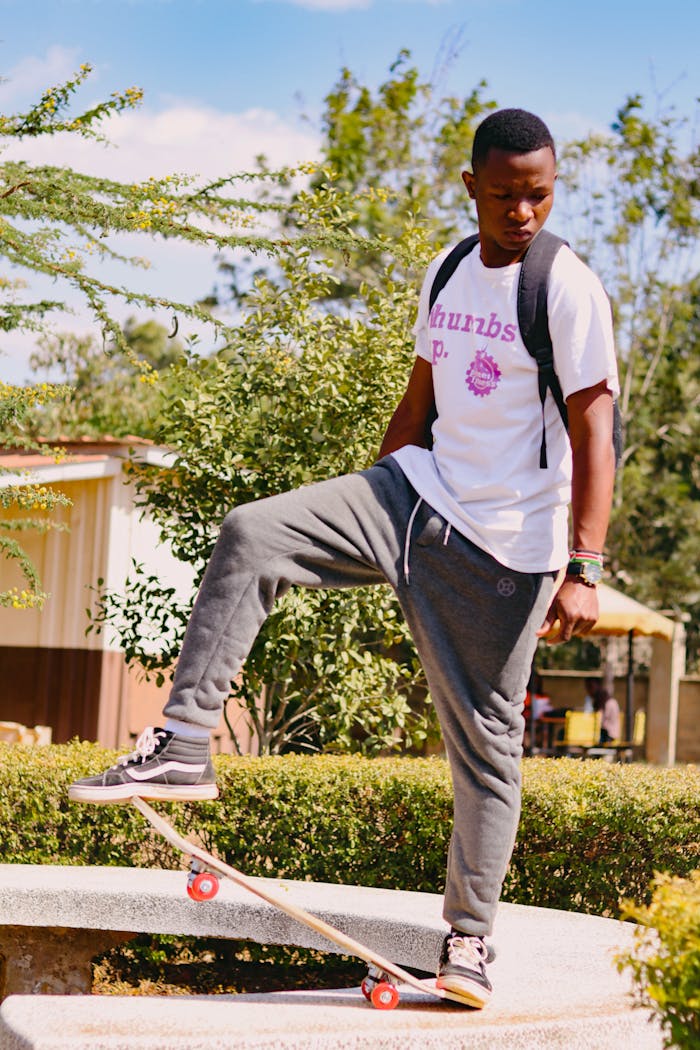 Man Standing on Bench with Skateboard